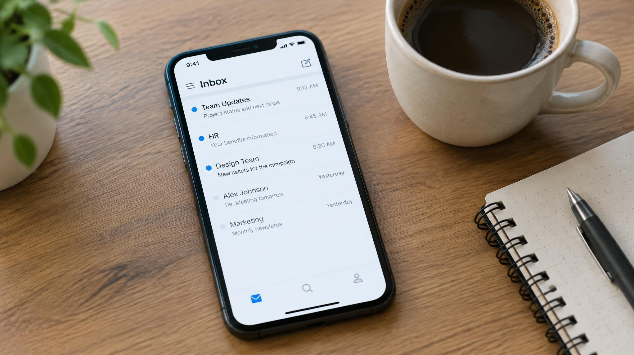 Smartphone showing an email inbox on a desk